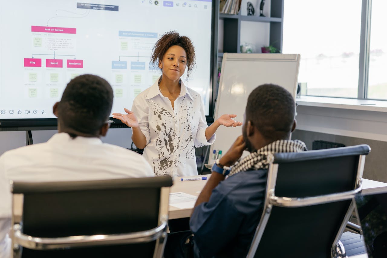 services-02 A woman leads a team meeting in a modern office using digital presentations.